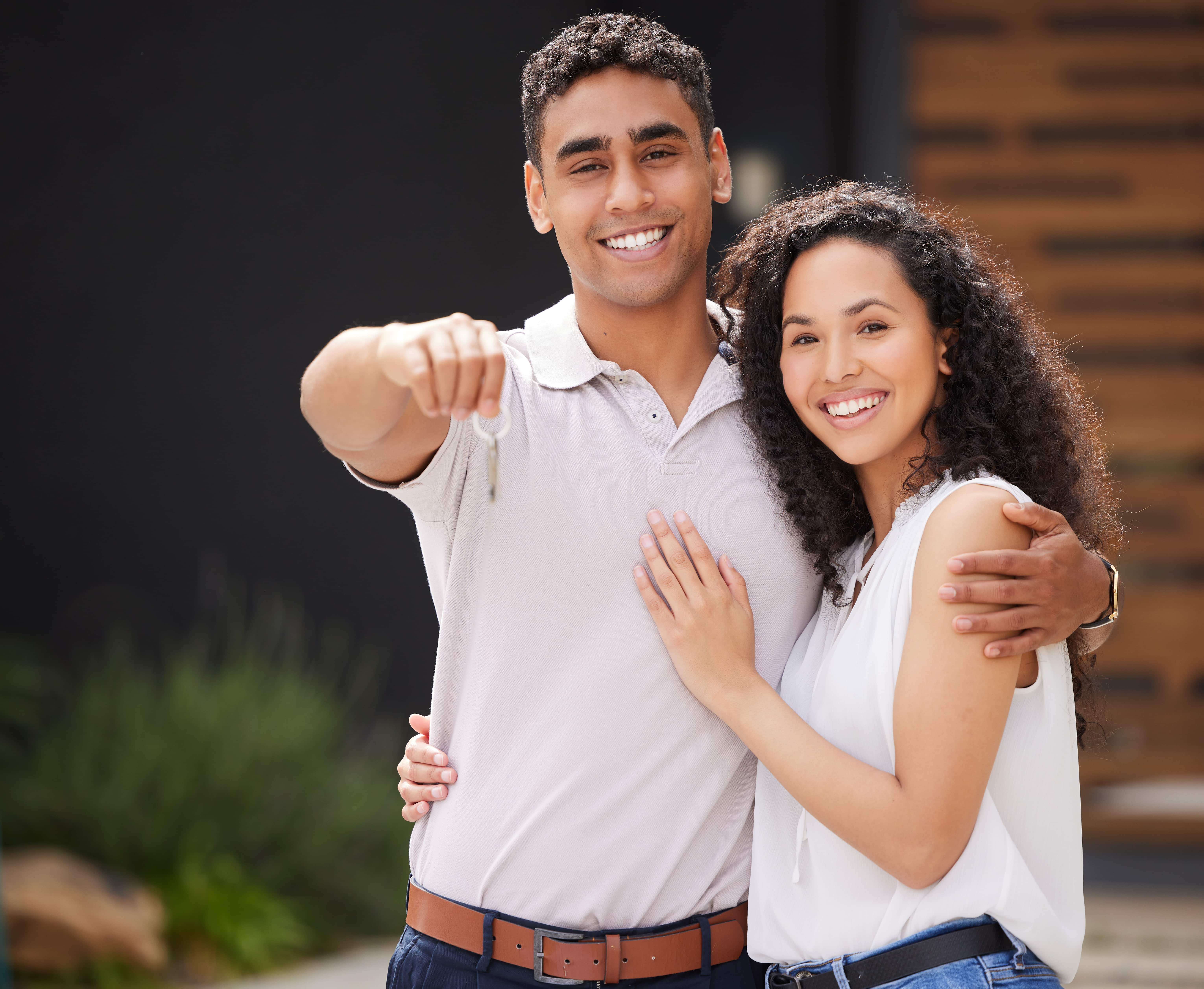 Pareja joven latina feliz vendiendo casa rápido en Monterrey