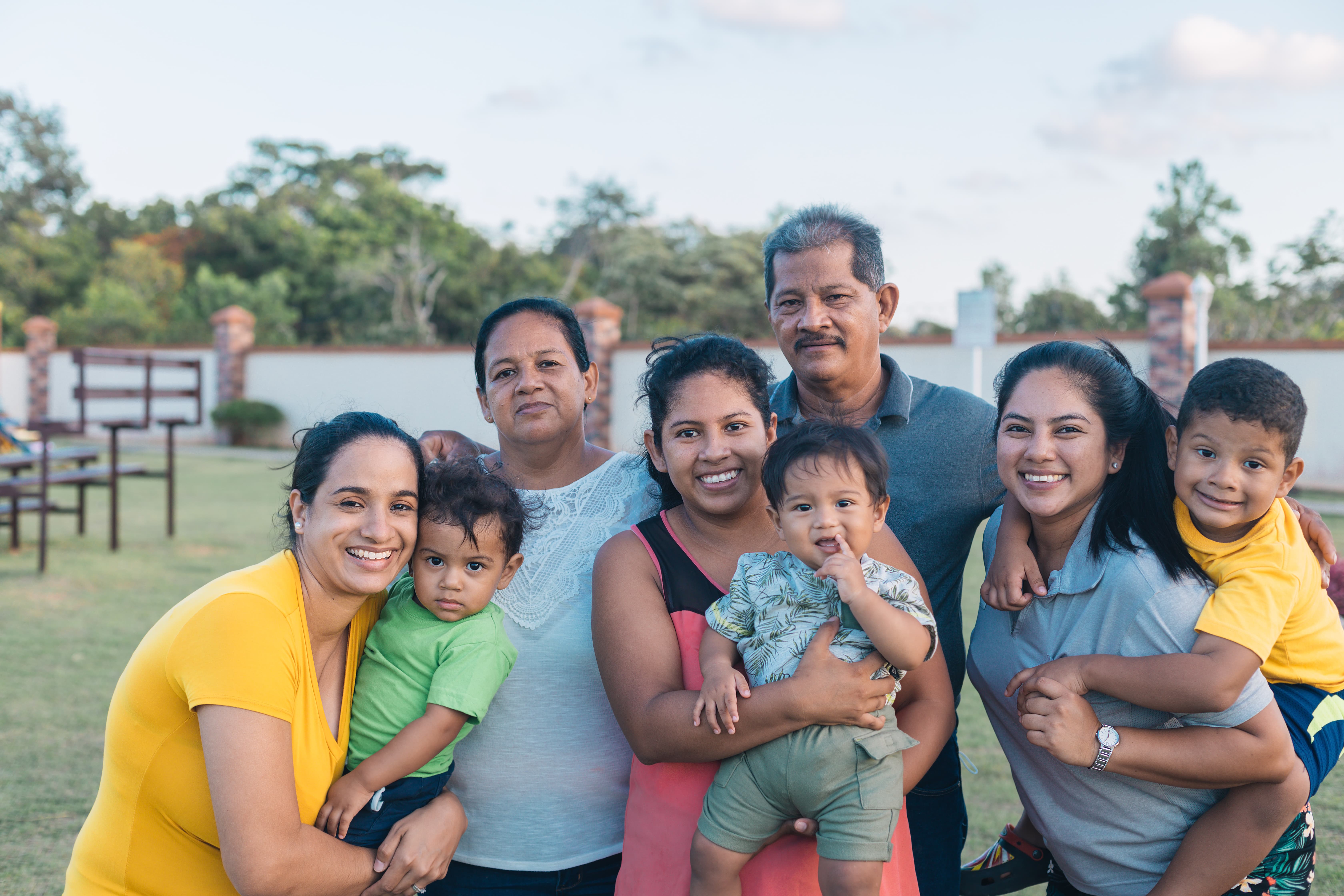Familia latina feliz después de resolver venta de casa abandonada